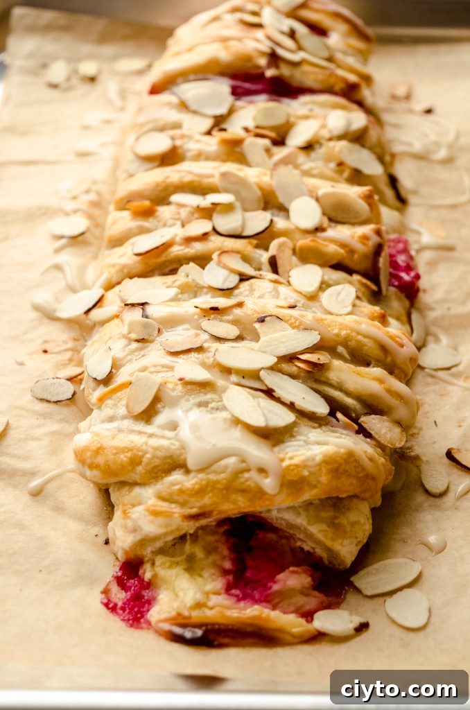 Raspberry Cream Cheese Danish Recipe 15 A pastry braid filled with raspberries and cream cheese with toasted almonds and an icing on it.