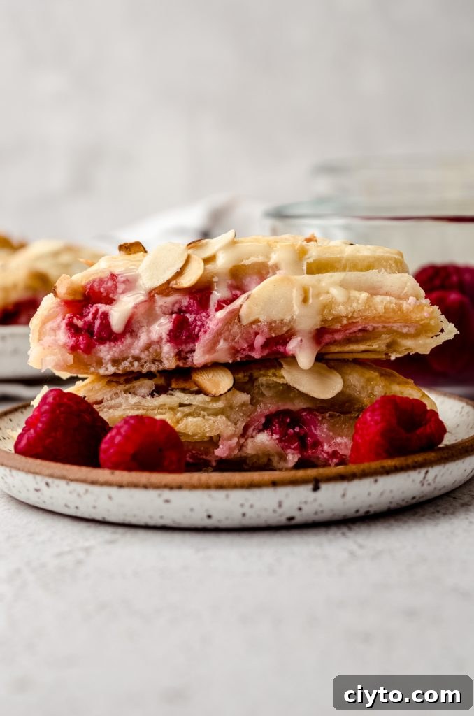 Raspberry Cream Cheese Danish Recipe 18 Slices of raspberry almond pastry stacked on a plate.