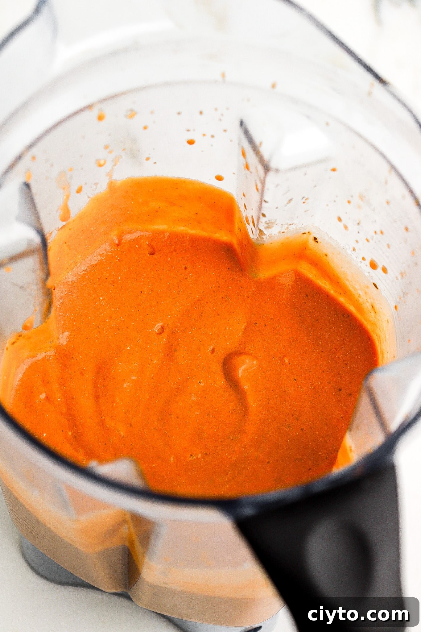 Side view of red sauce in a blender.