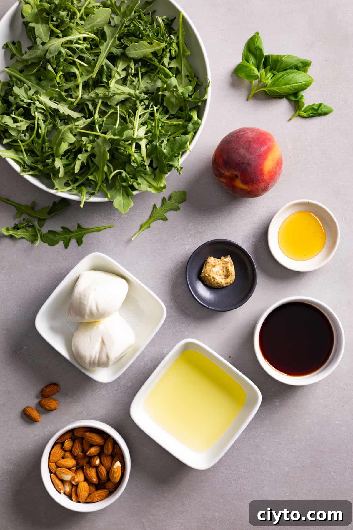 Arugula and Burrata Salad Recipe with Lemon Vinaigrette 3 Ingredients for a burrata arugula salad on a gray table.