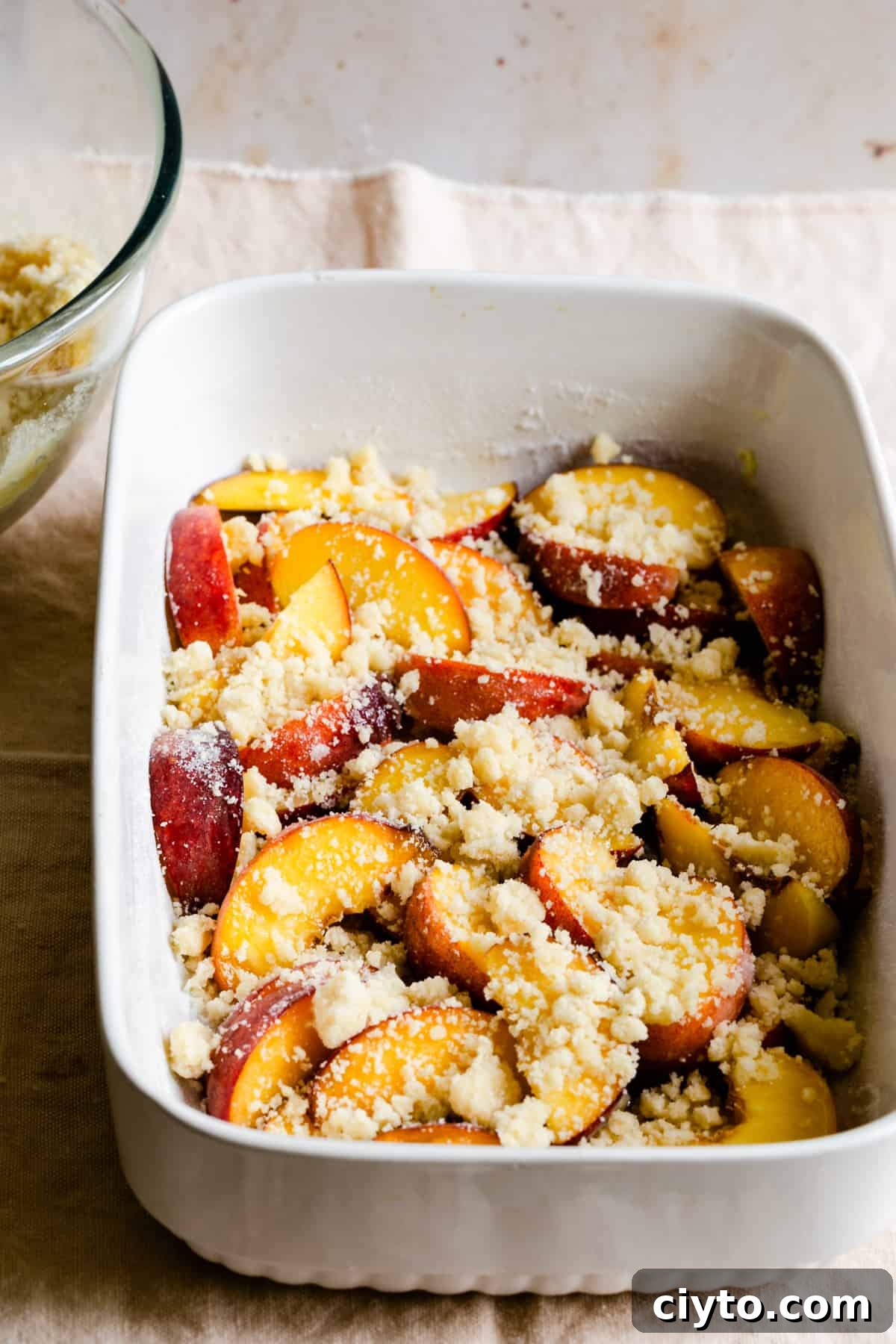 baking dish with sliced peaches and cobbler topping