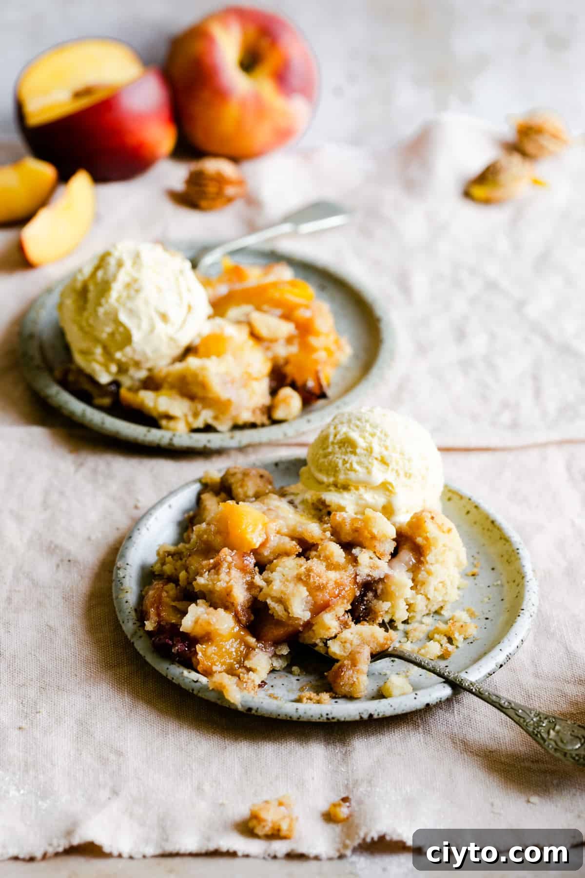 two portions of peach cobbler with some ice cream
