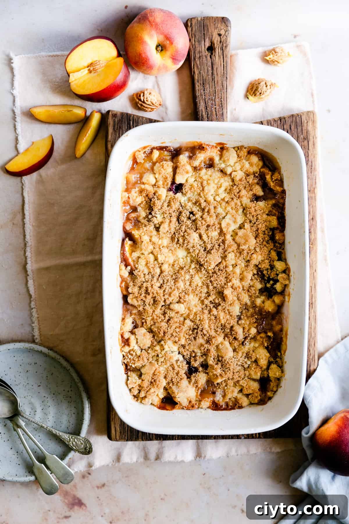 overhead shot of a peach cobbler on a wooden chopping board