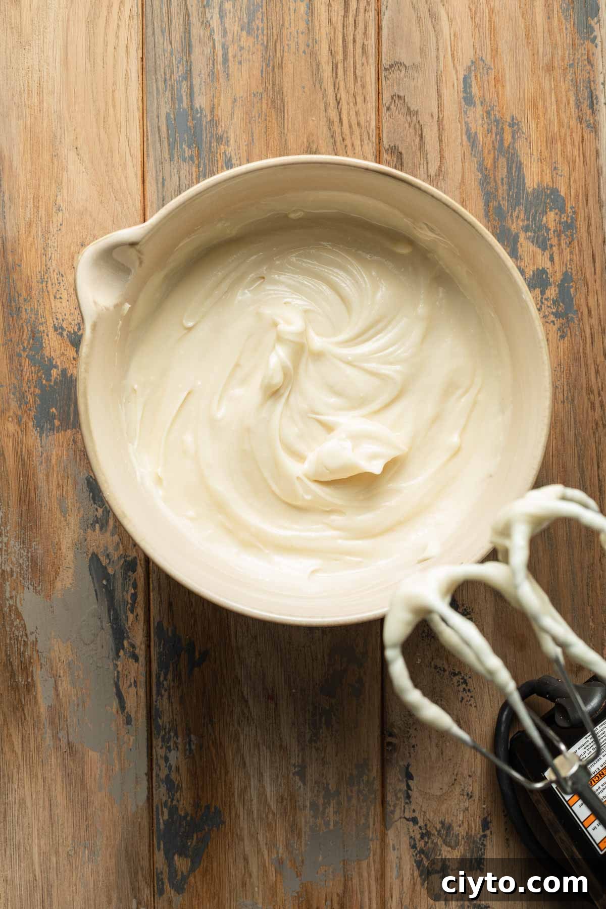 Overhead view of cream cheese frosting in a bowl.