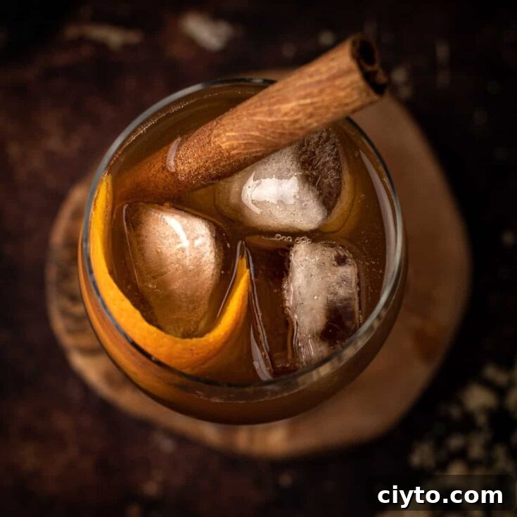 Overhead view of a brown sugar old fashioned cocktail garnished with a cinnamon stick and orange peel.