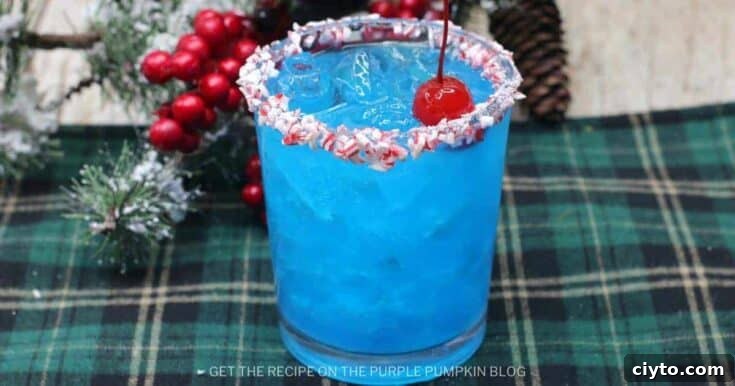 A blue peppermint schnapps cocktails with a candy cane rim.