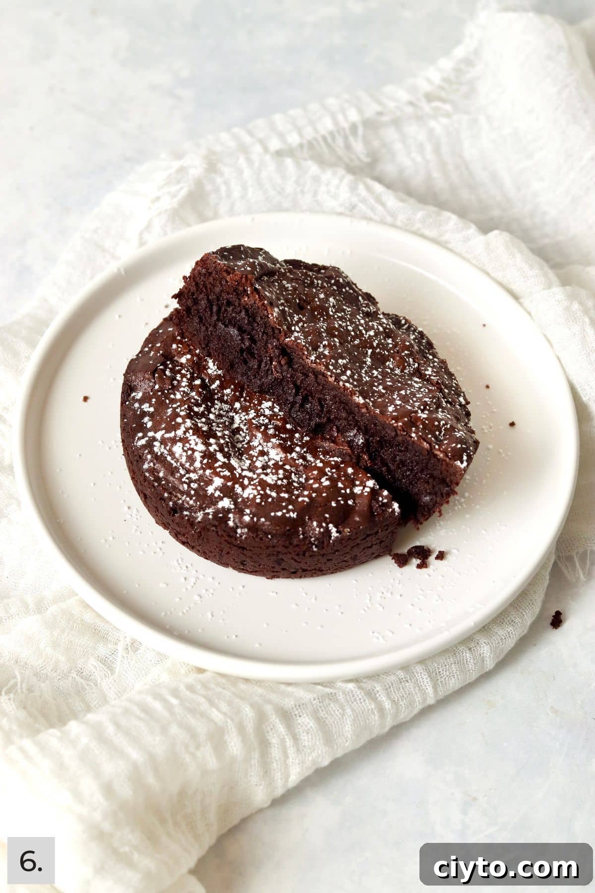Single serve fudgy brownie cut in half on a plate.