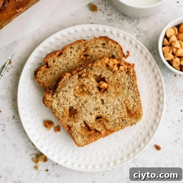 Two slices of Banana Bread on a small white plate with a cup of milk and a small cup of butterscotch chips on the side.