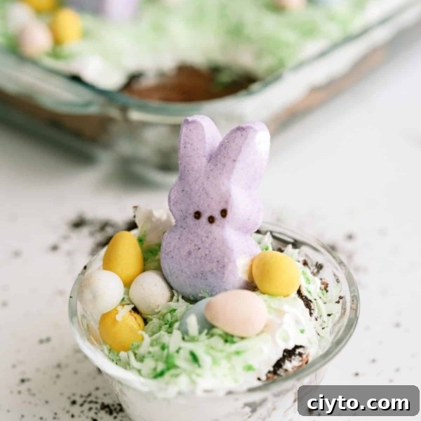A serving of Easter Bunny Pudding Dirt Cake in a small plastic cup.