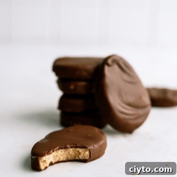 Homemade Reese’s Eggs stacked with one of to the side with a bite missing.