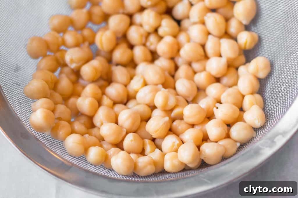 How to Make Creamy Homemade Hummus 2 chickpeas in a metal mesh strainer