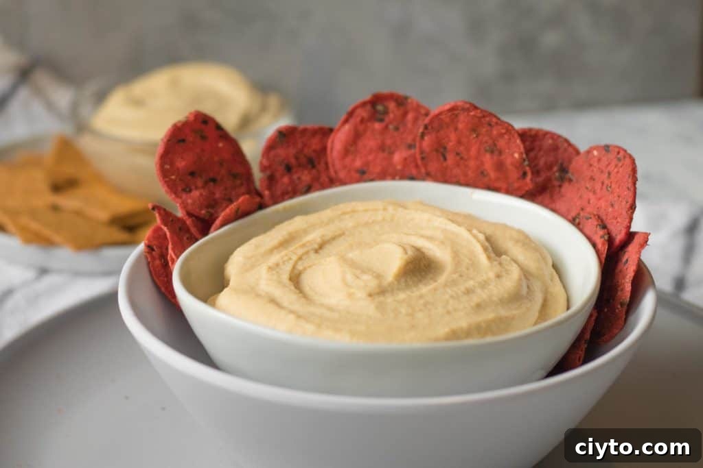 How to Make Creamy Homemade Hummus 3 homemade hummus in a white bowl with beet crackers around the edge