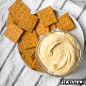 How to Make Creamy Homemade Hummus 5 homemade hummus in a small glass dish with wheat crackers on a plate