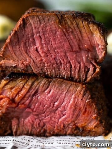 Grilled filet mignon steak cut in half and stacked on itself showing medium rare cook.