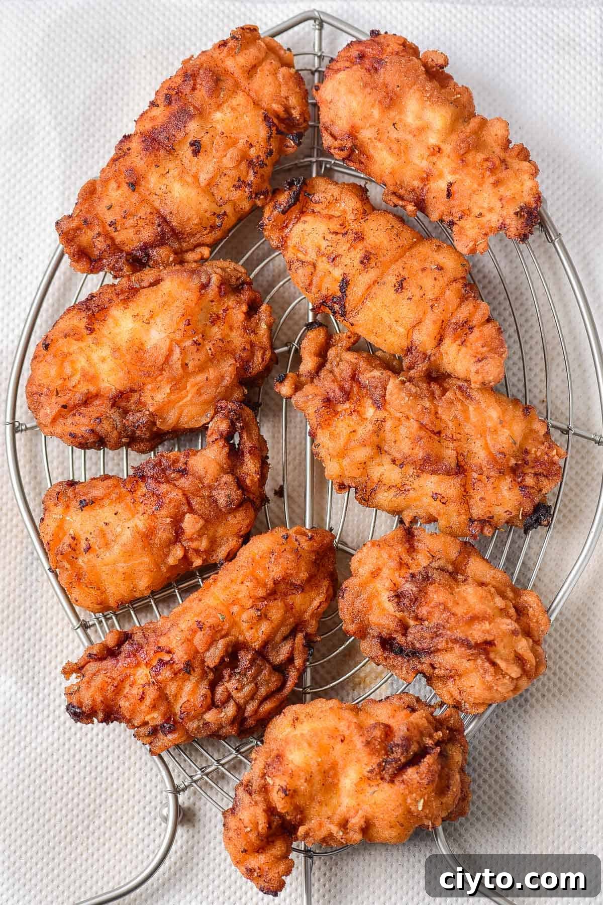 Draining fried chicken on a rack.
