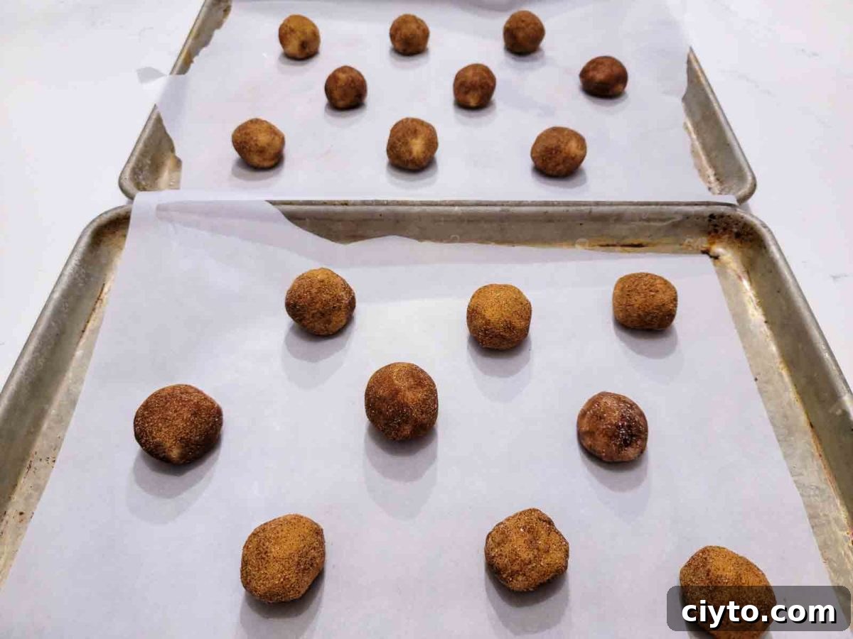 toffee doodle cookies rolled into balls and ready to bake on cookie sheets.