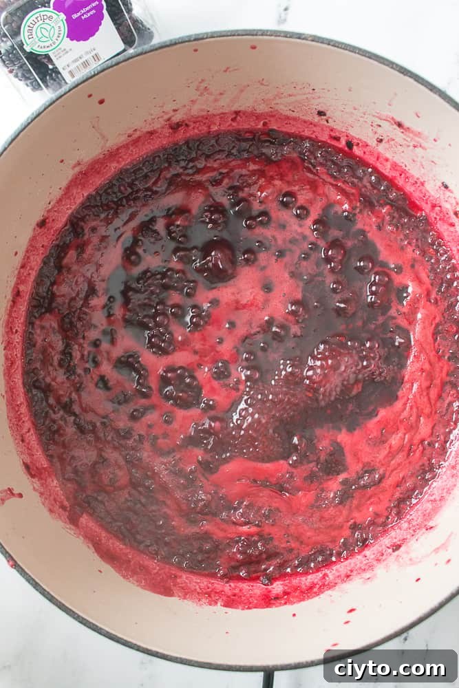 overhead shot of blackberry jam boiling in Dutch oven