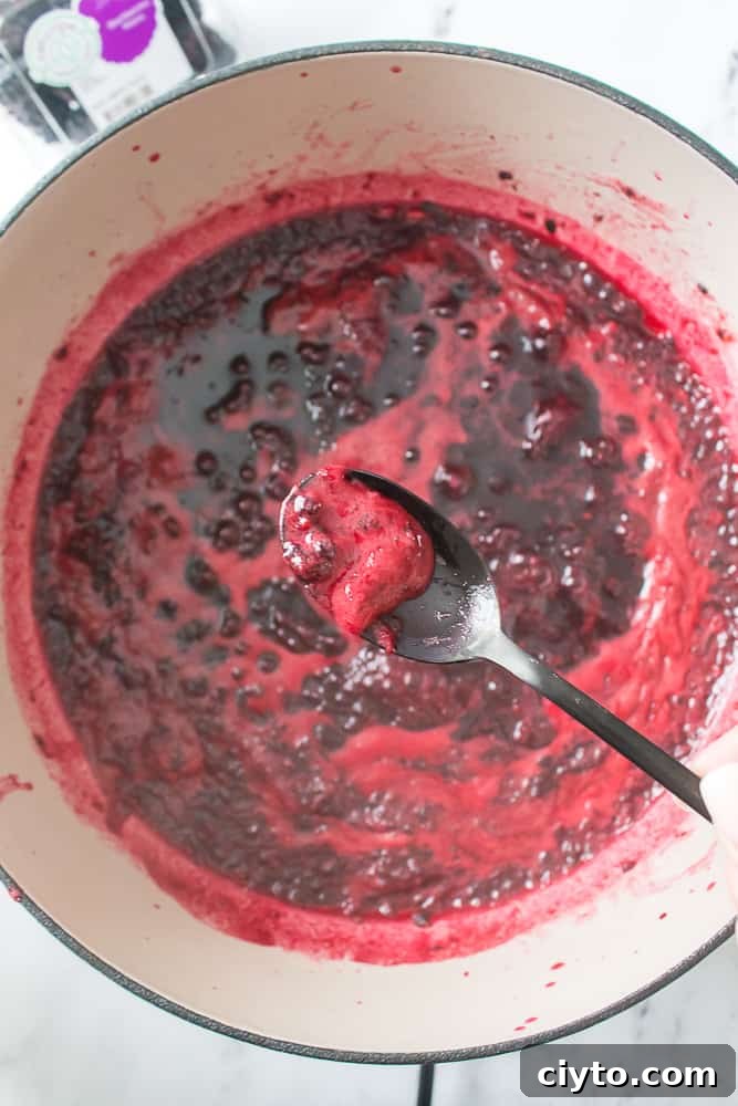 overhead shot of black spoon with foam from boiling jam
