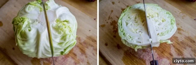a wooden cutting board with a knife slicing a green cabbage in half.