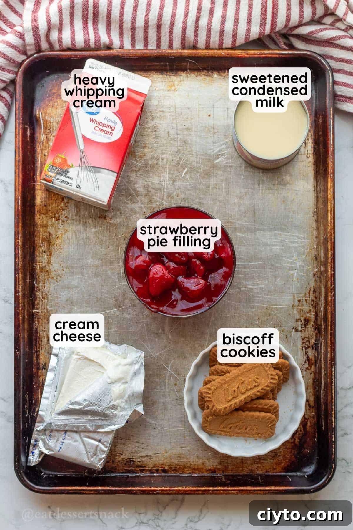 Labeled ingredients for strawberry cheesecake ice cream in metal pan.