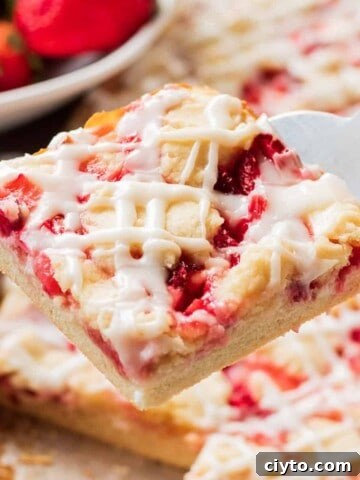 Sliced of baked strawberries and cream bar on a spatula.