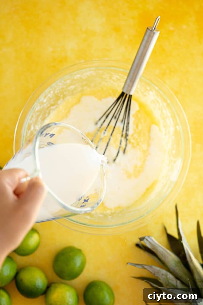 Moist Pina Colada Cake Recipe with Fresh Pineapple 5 milk pouring into a bowl