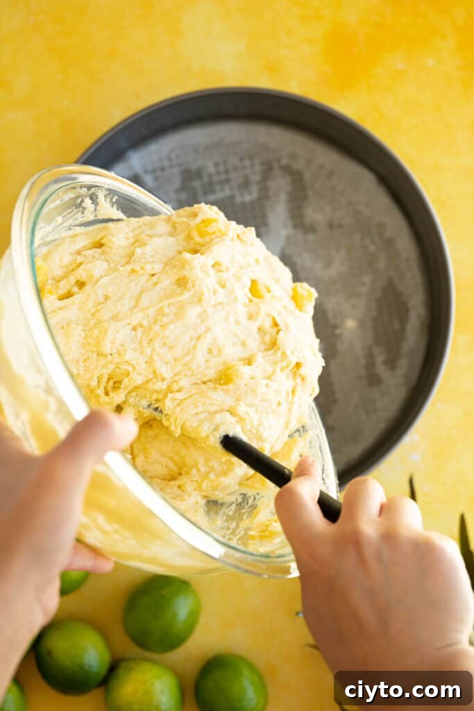 Moist Pina Colada Cake Recipe with Fresh Pineapple 7 pina colada cake batter pouring into a pan