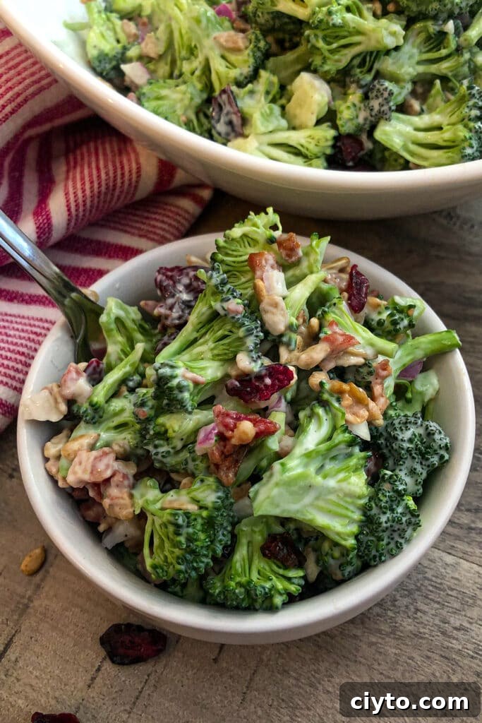 Broccoli salad in a serving bowl with a fork for eating