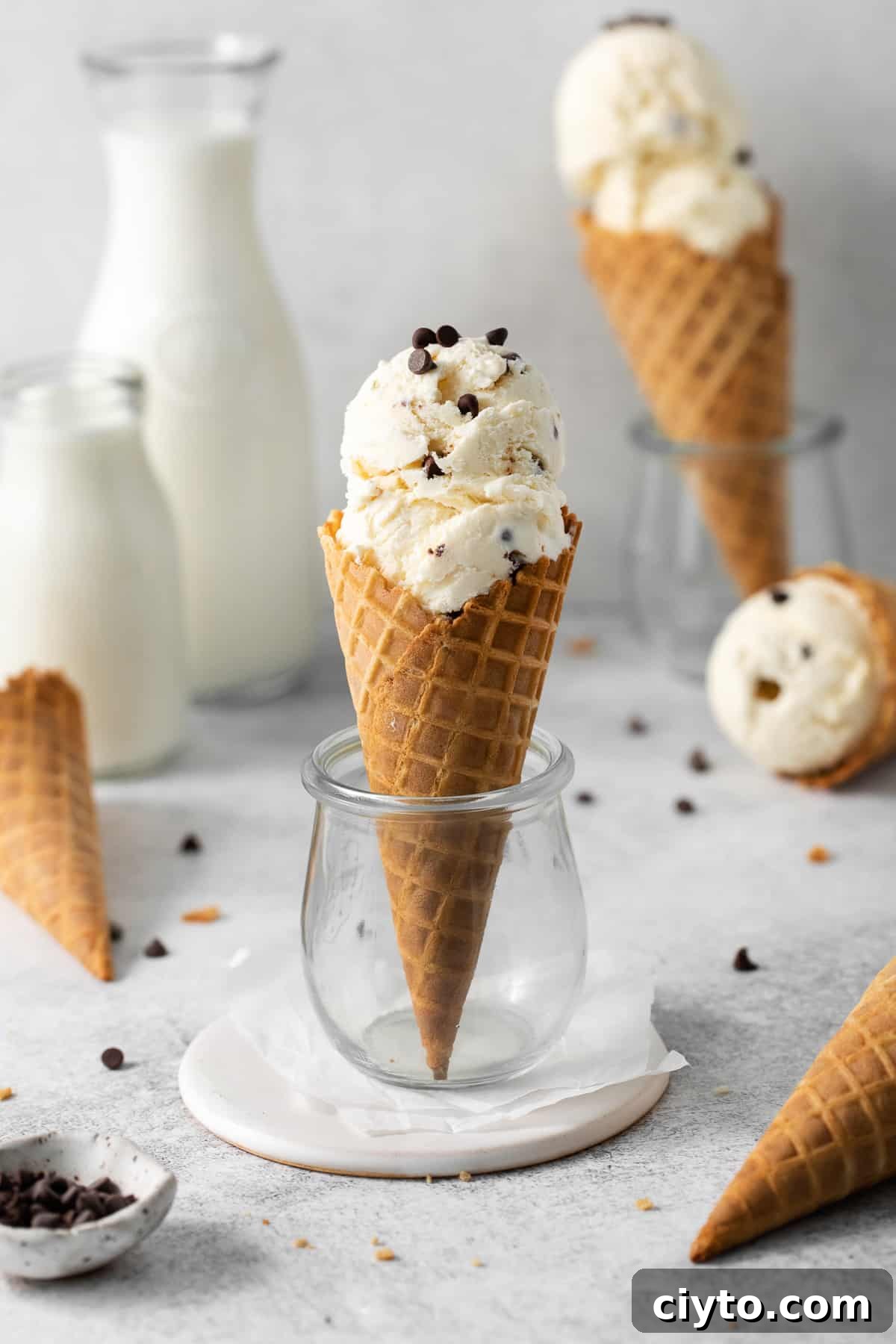 Cannoli Ice Cream Recipe with Ricotta and Chocolate Chips 6 Ice cream cone filled with cannoli ice cream on a counter.