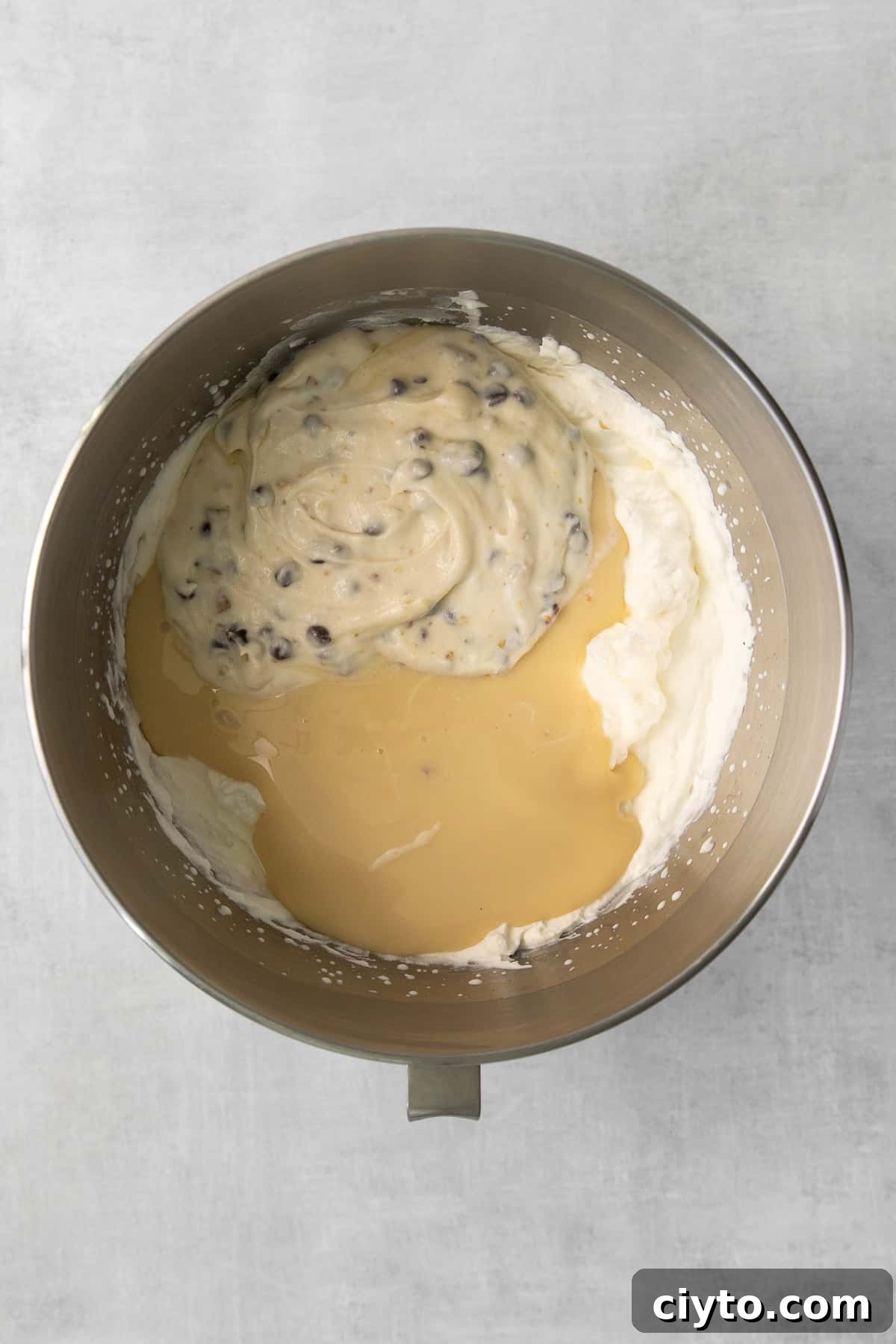 Cannoli Ice Cream Recipe with Ricotta and Chocolate Chips 4 Sweetened condensed milk and whipped cream in a bowl ready to be folded into cannoli mixture.