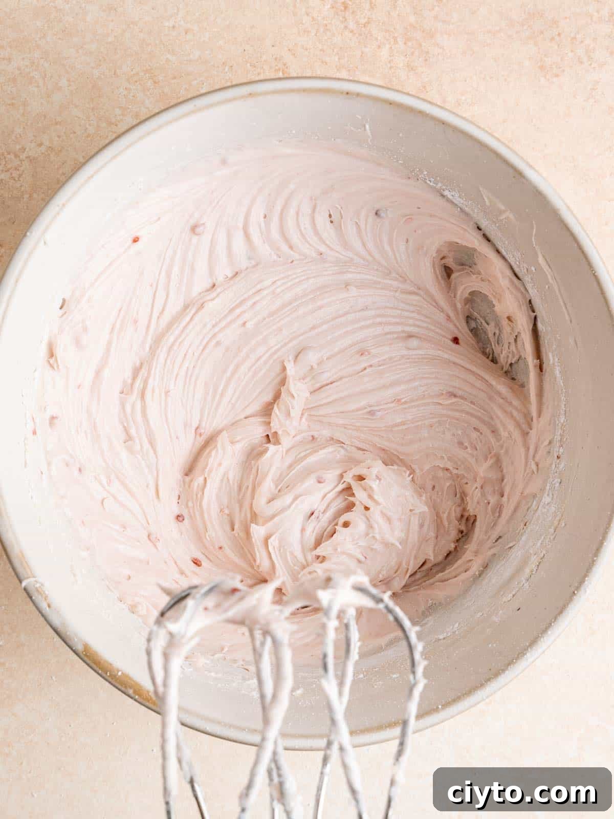 Raspberry cream cheese frosting in a bowl.