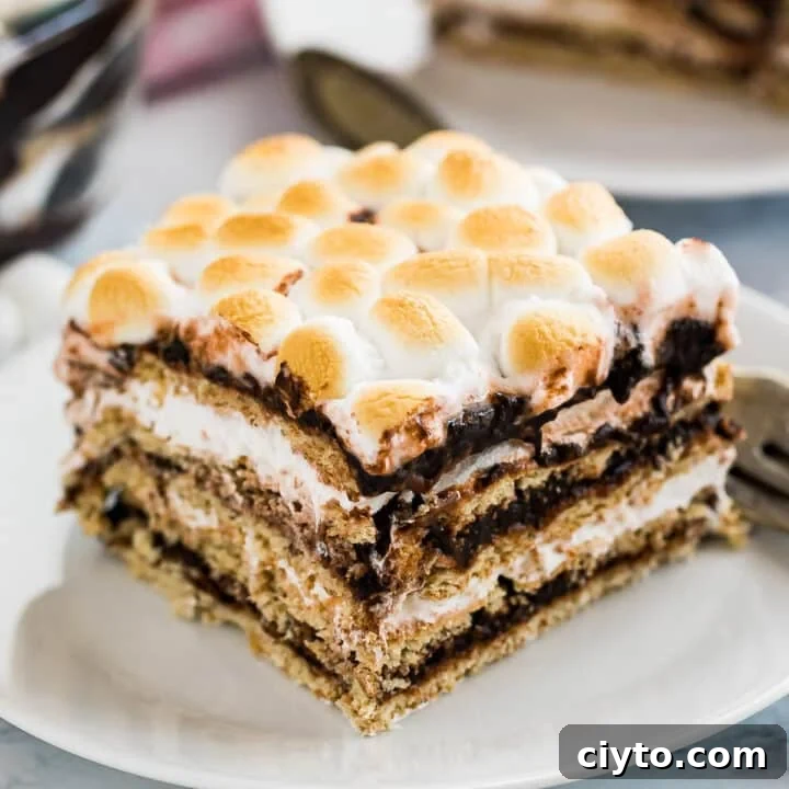 A slice of s'mores icebox cake on a white plate with more in the background.