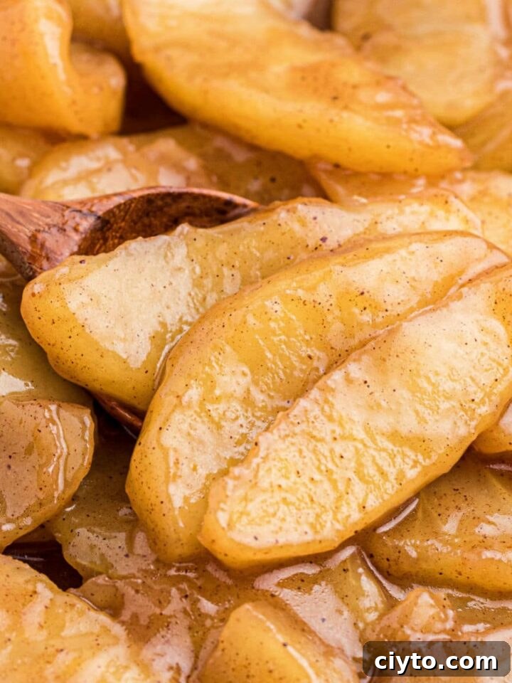 Close up of fried apples with a wooden spoon.