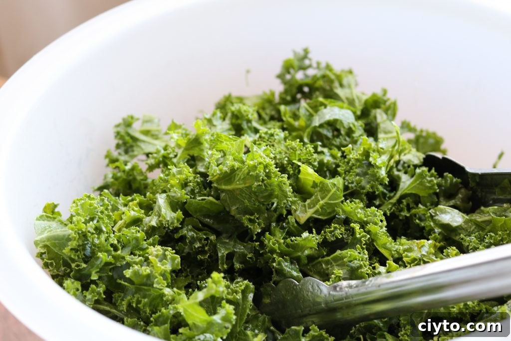 kale in white plastic bowl with tongs 