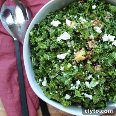 sweet kale quinoa salad in white bowl with serving spoons