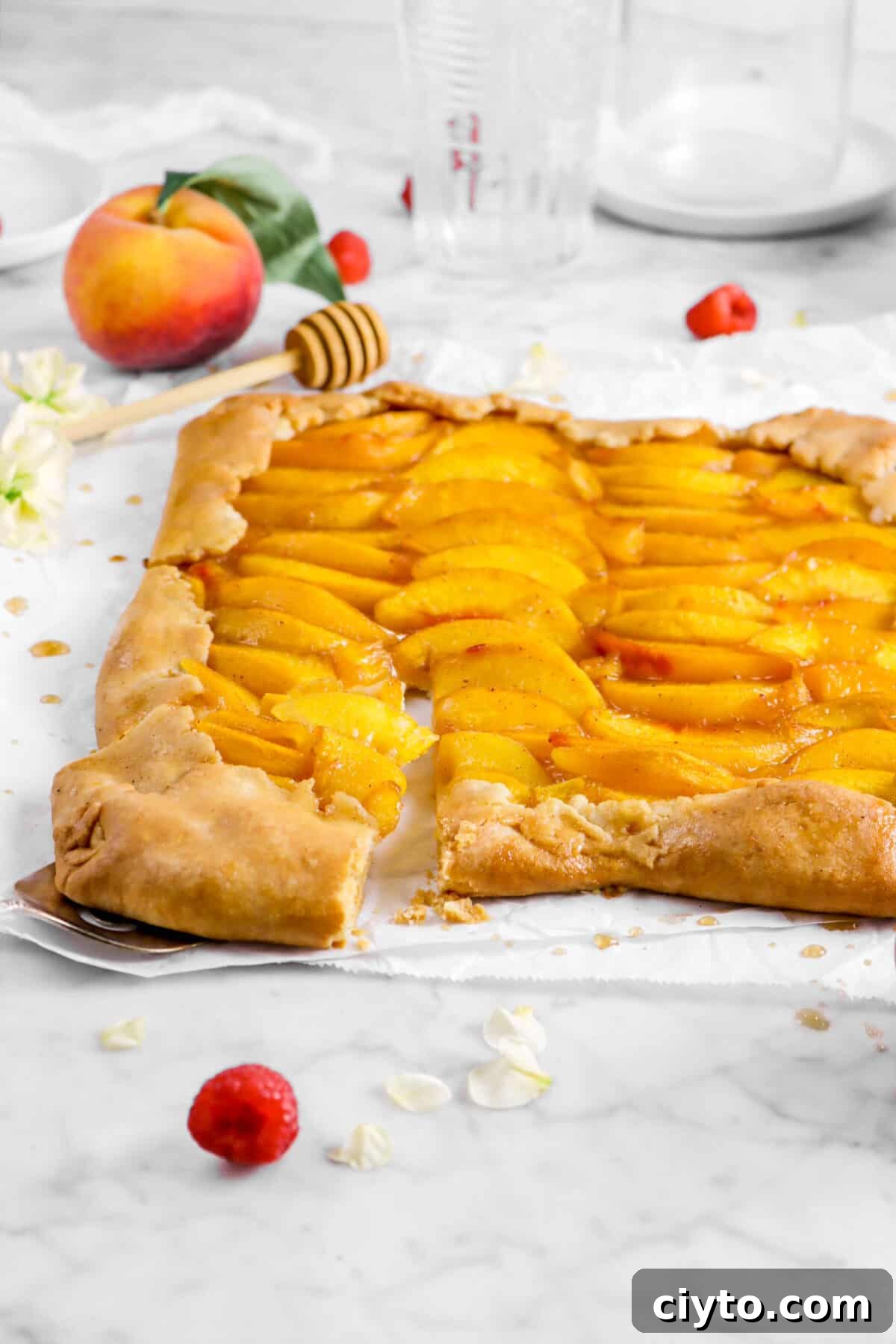 front shot of peach galette with a slice being pulled out
