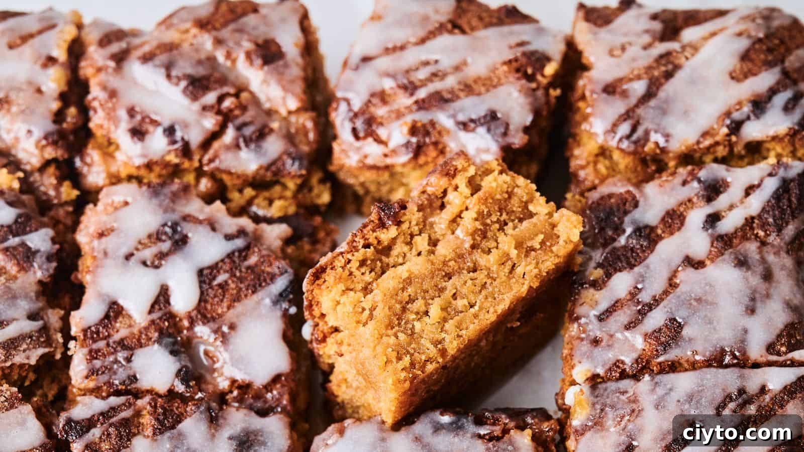 Close-up of sliced crumbly cakes topped with white icing. One piece is positioned vertically to show its texture.