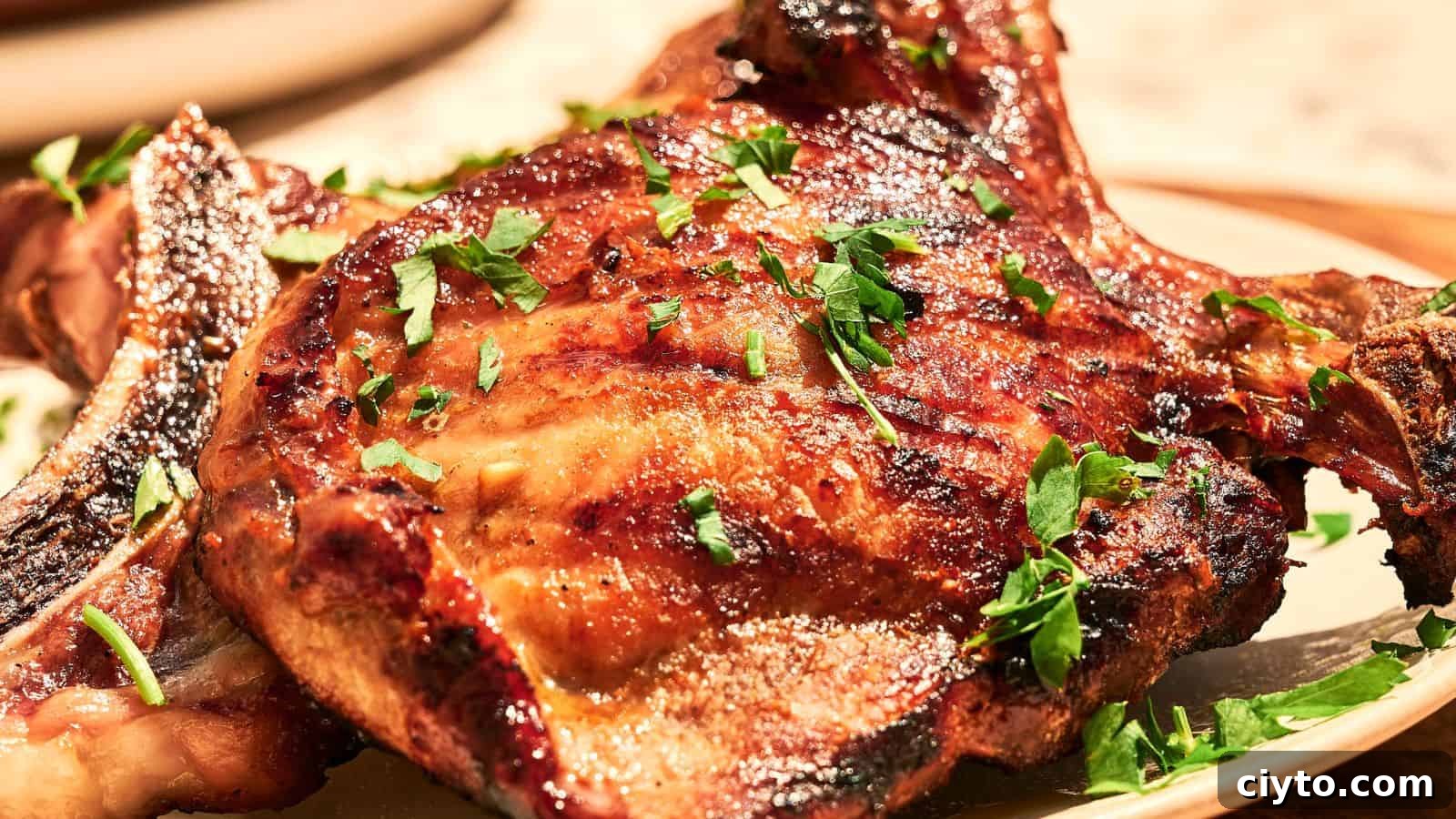 A grilled pork chop garnished with chopped parsley is served on a plate.