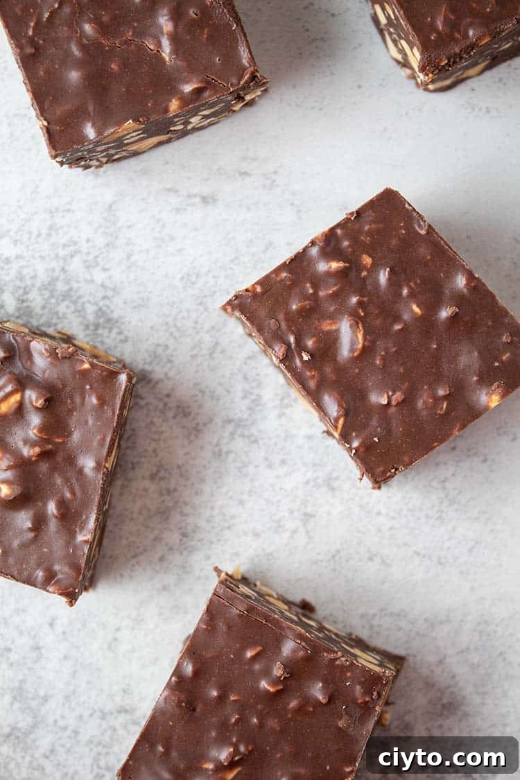Low-Carb Peanut Butter Crunch Bars, Gluten Free, No Added Sugar 11 overhead vieww of homemade crunch bars laying on a white surface spread out randomly