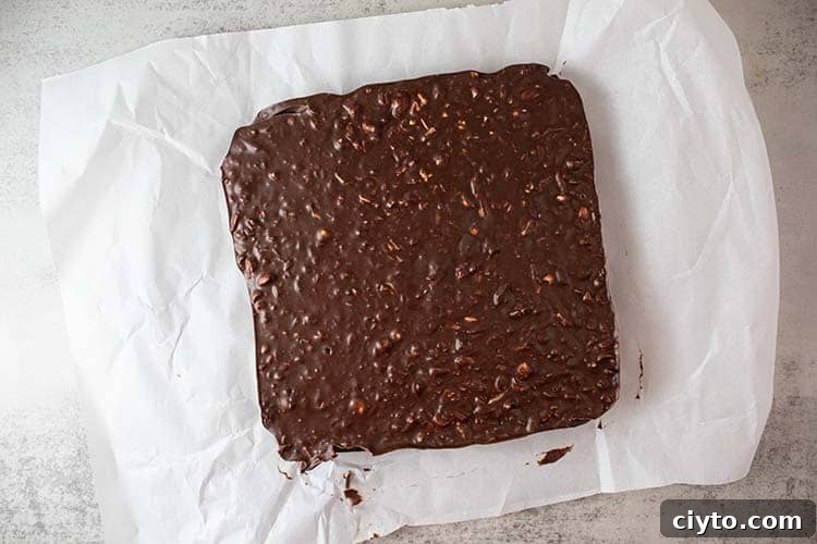 Low-Carb Peanut Butter Crunch Bars, Gluten Free, No Added Sugar 4 overhead view of how to make crunch bars after refrigeration and ready to be cut and served on white parchment paper
