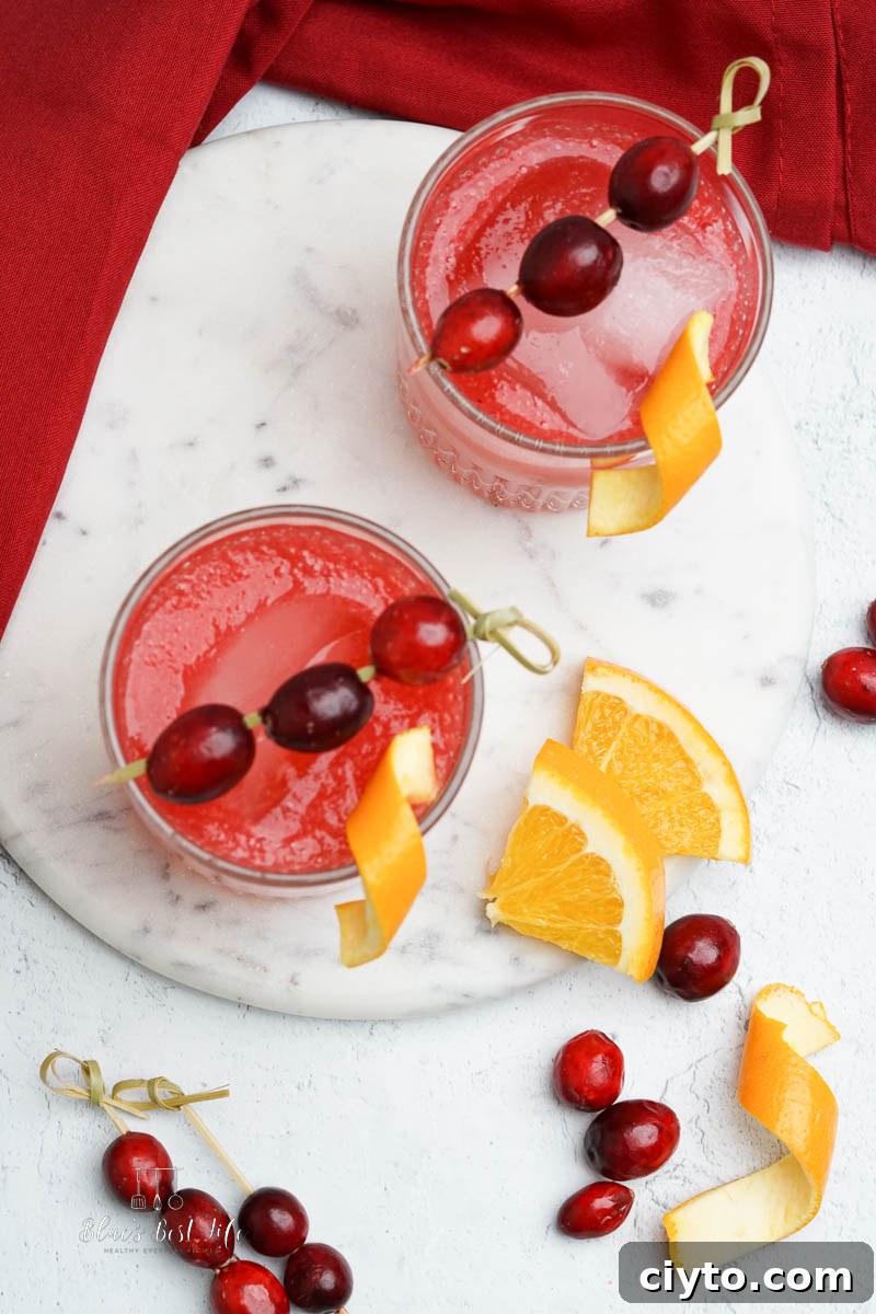 Vodka Spritzer with Homemade Cranberry Syrup 6 the cranberry drinks on a countertop with orange slices