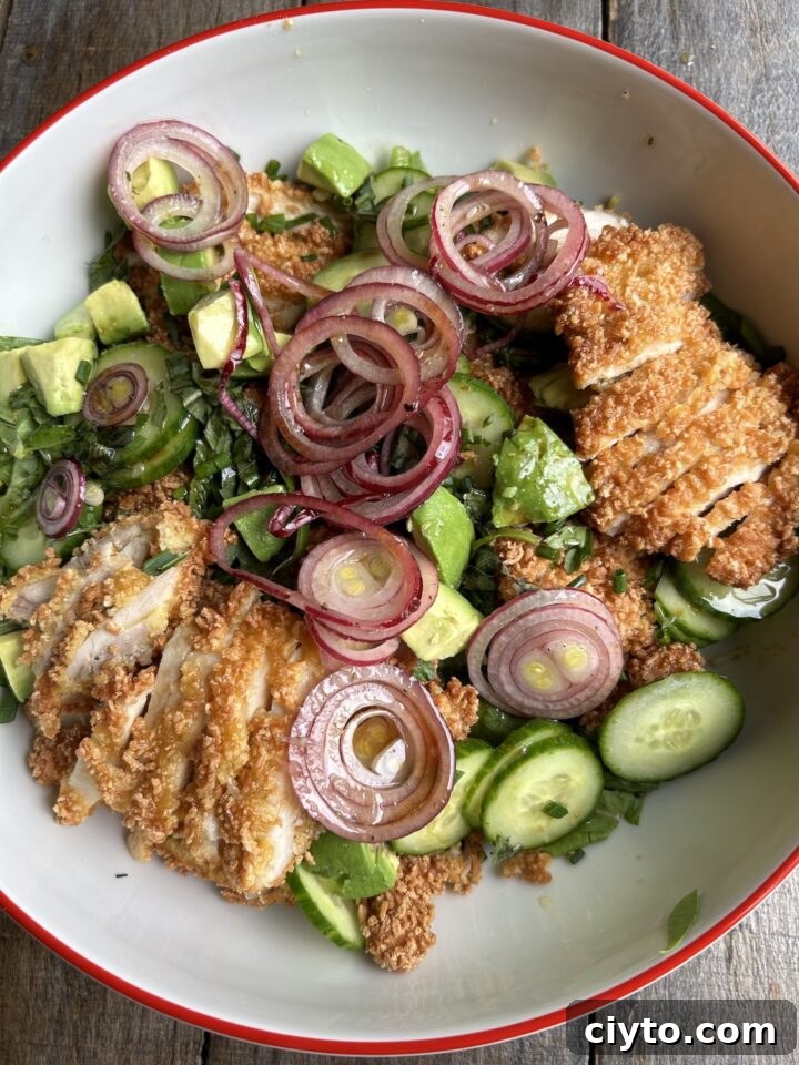 New Year's Eve Dinner Recipes and Menu Ideas 9 a photo of crispy chicken on a green salad in a white bowl