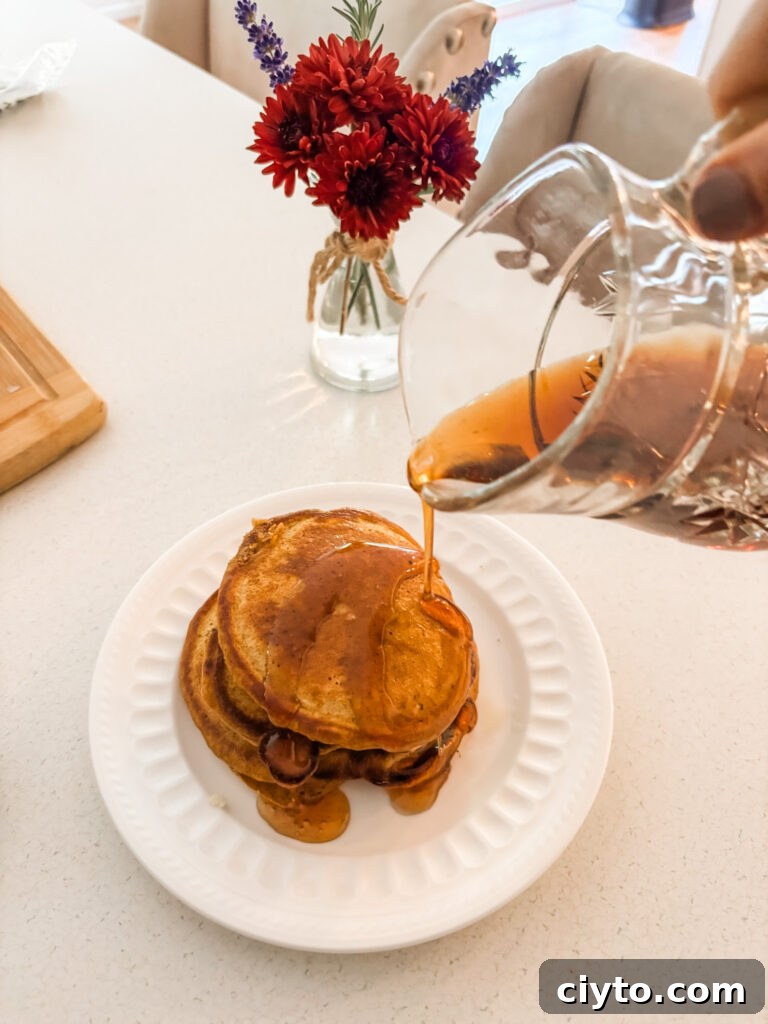 Marie pouring syrup on top of the Pumpkin Spice Pancakes