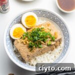 braised tofu over rice with soft boiled eggs, scallions and tempura scraps