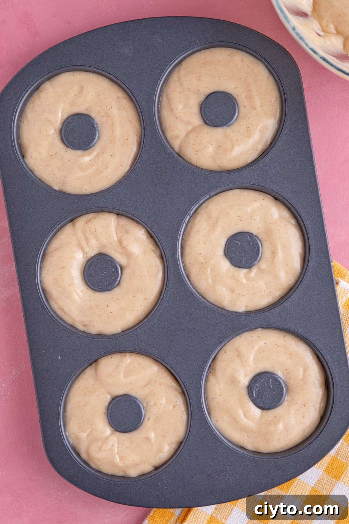 Batter added to the doughnut tin before baking.