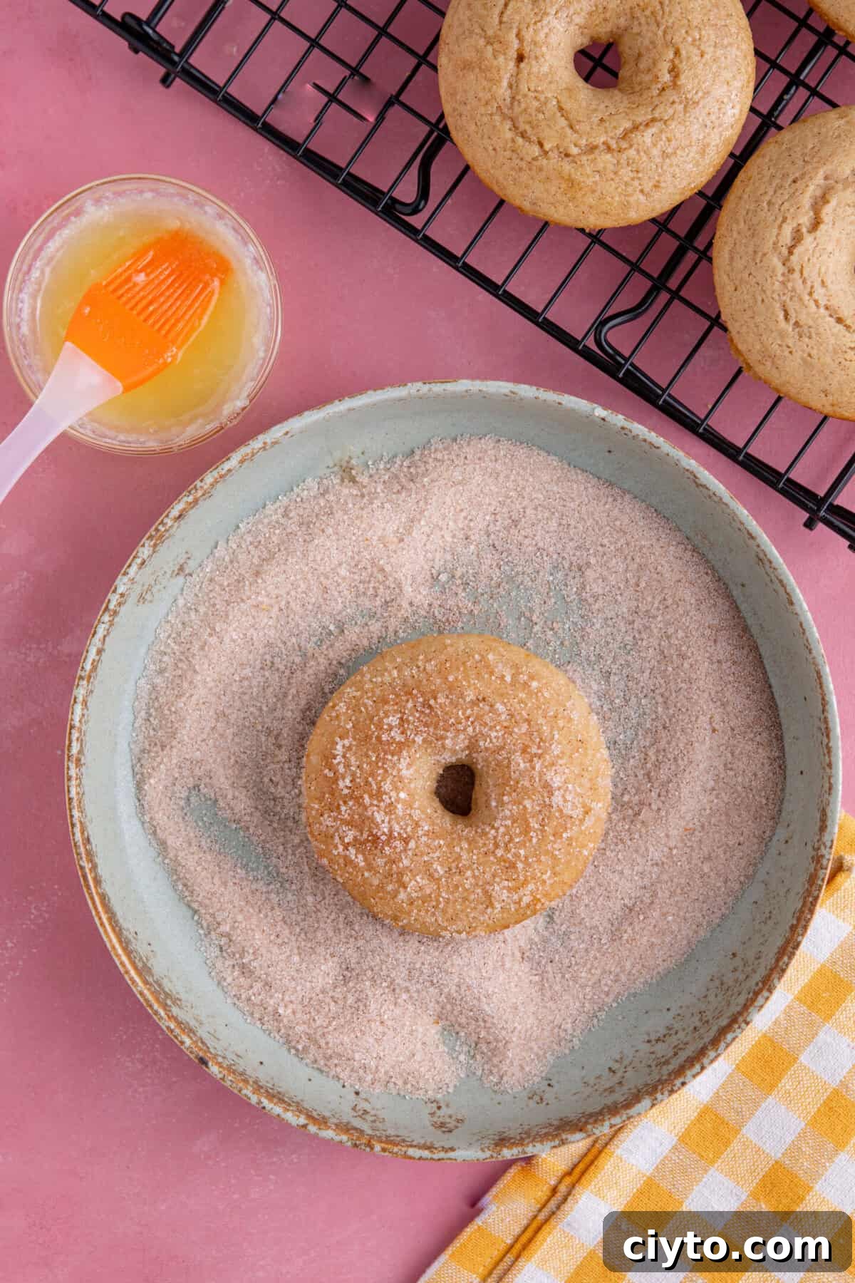 Doughnuts getting coated in sugar.