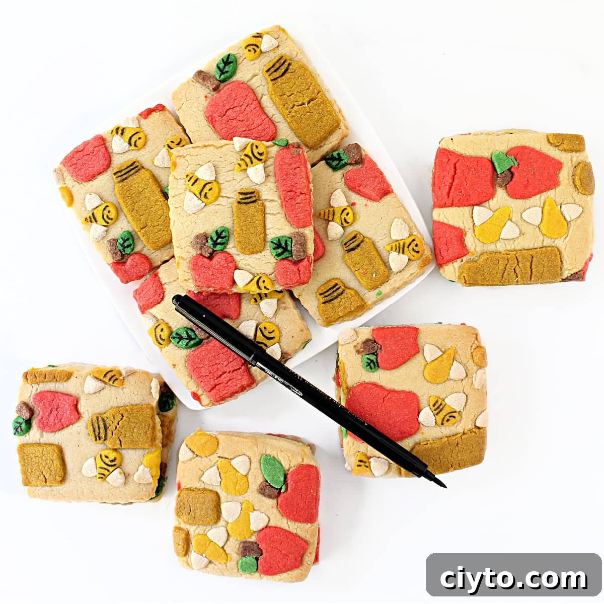 Rosh Hashanah Patterned Cookies: Creative Designs and Ideas 7 Baked cookies with colorful dough cutouts designs, details added with a black food coloring marker.