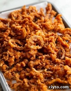 Crispy Fried Onions fried onions fresh out the fryer on baking tray