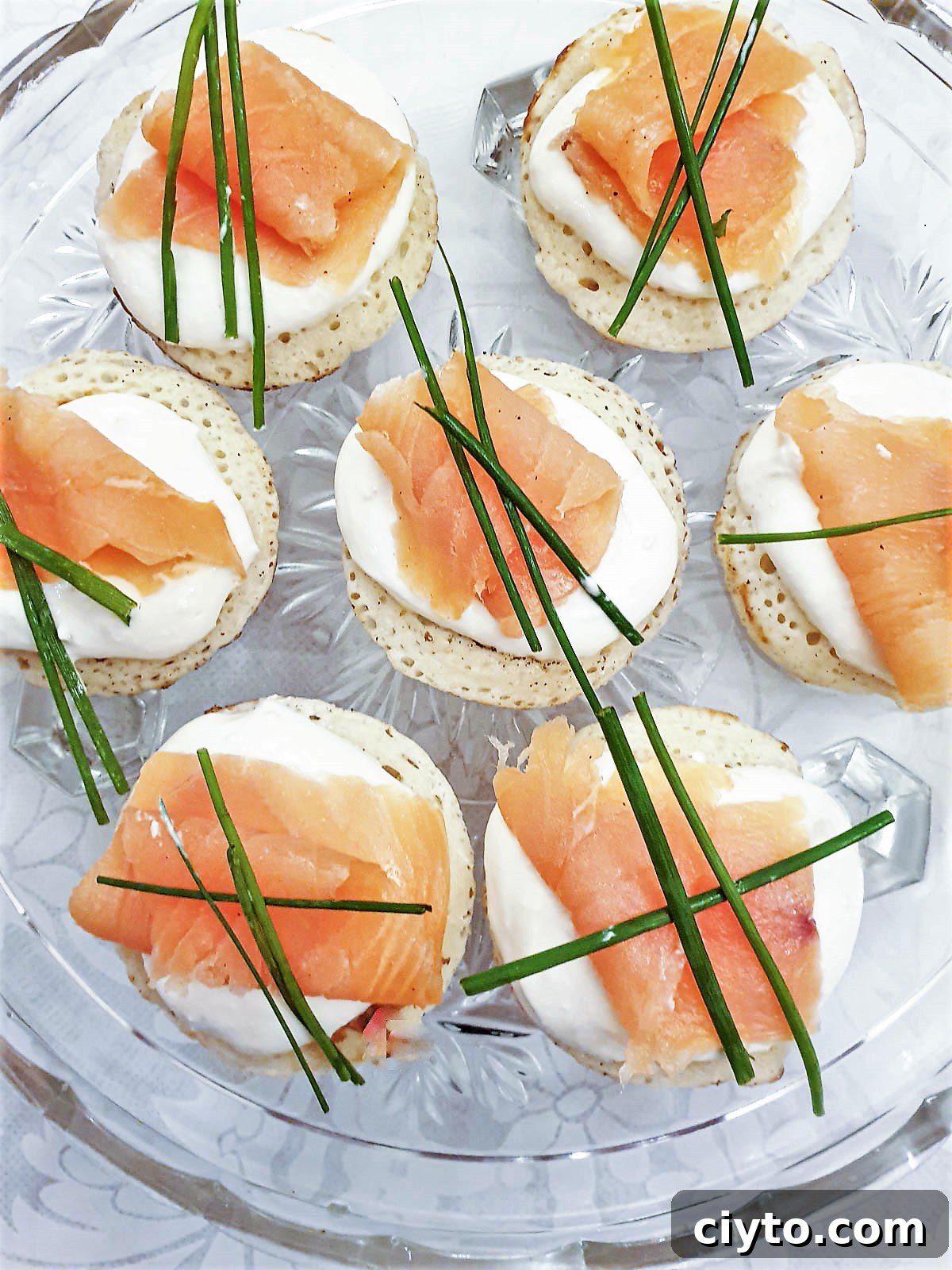 Closeup of blinis topped with creamy horesradish and smoked salmon.