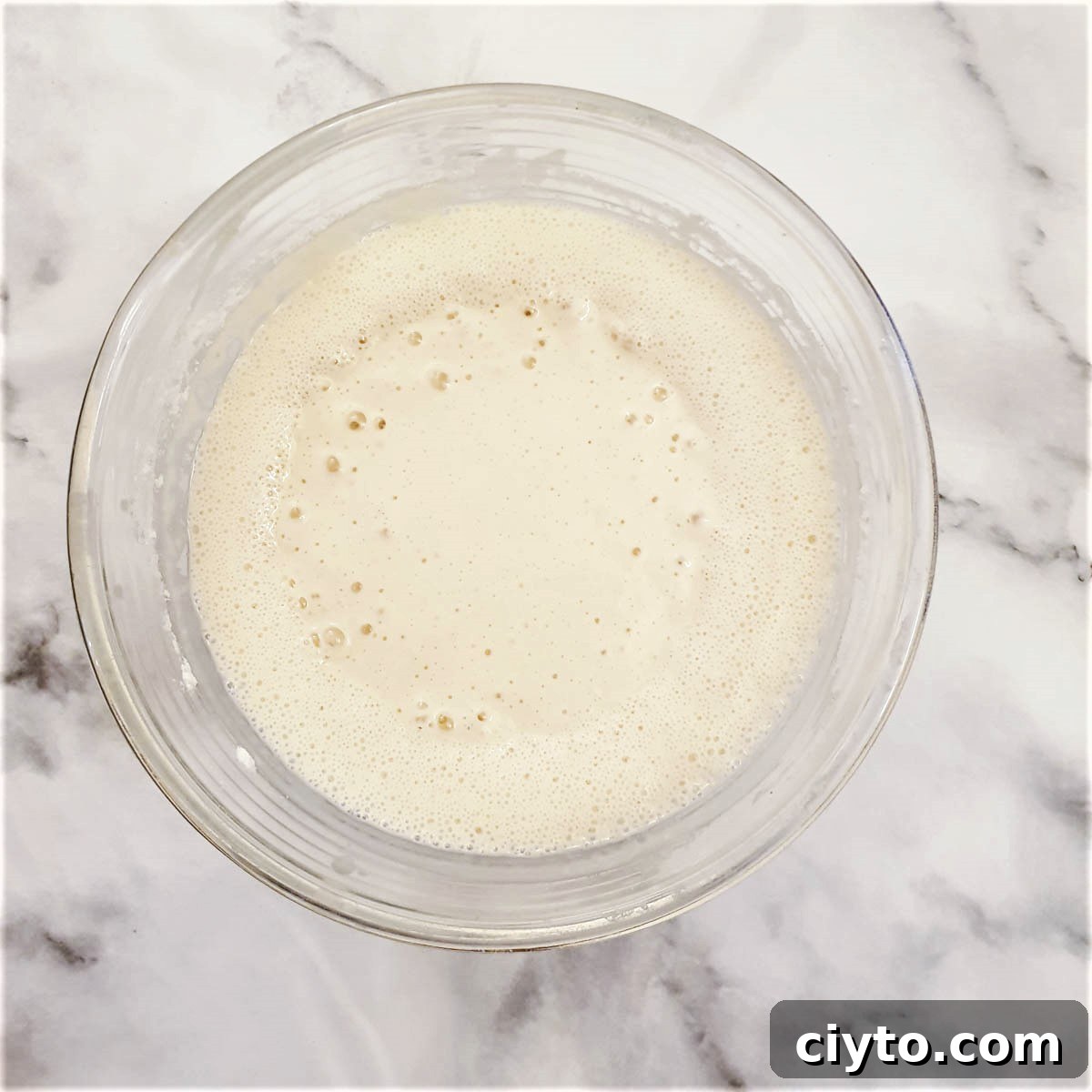 Blini batter after it has stood for an hour, showing the bubbles that have formed on top.